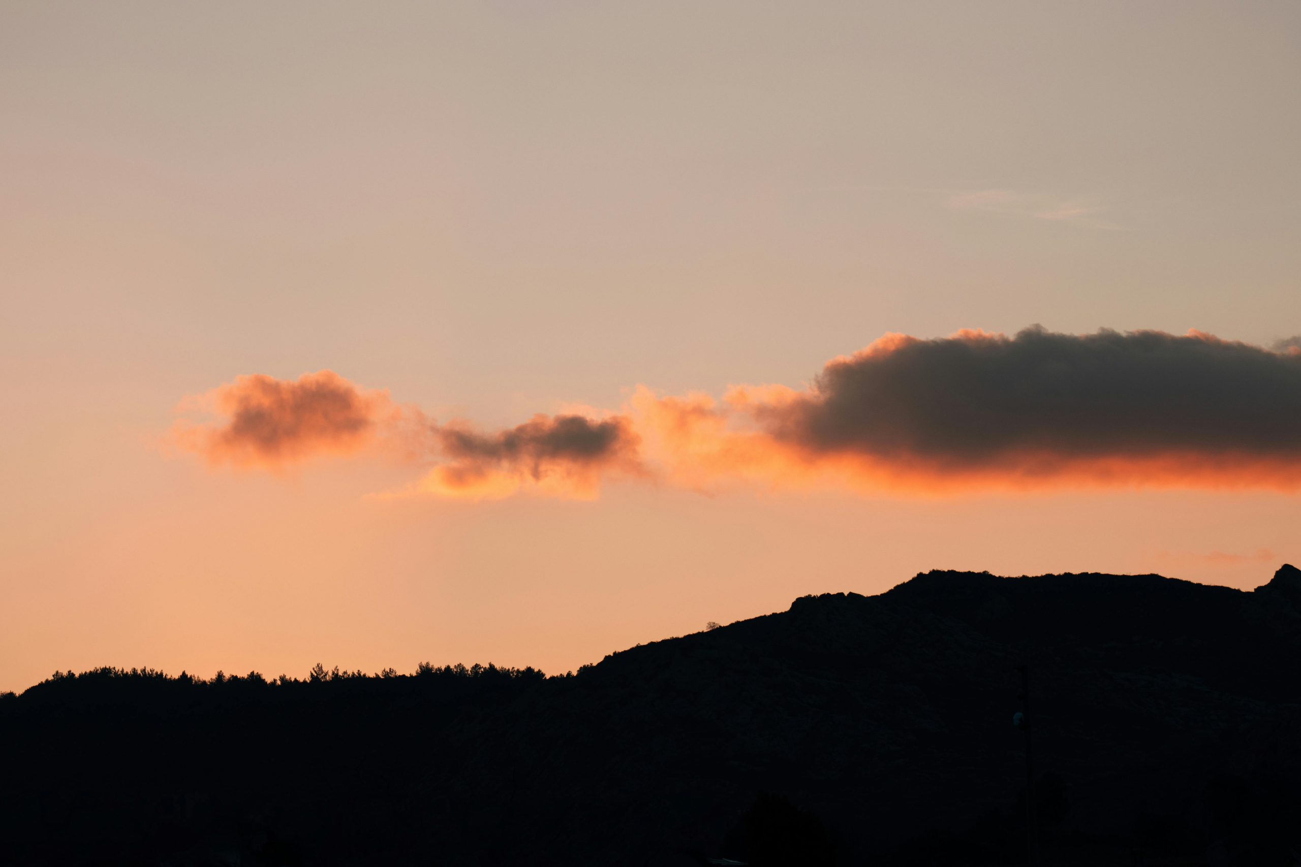 A breathtaking view of the sunset casting vivid colors over the hills of Urla, Türkiye.